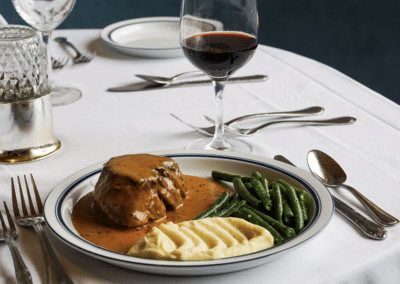 Steak au Poivre and Wine on Table at Le Chene